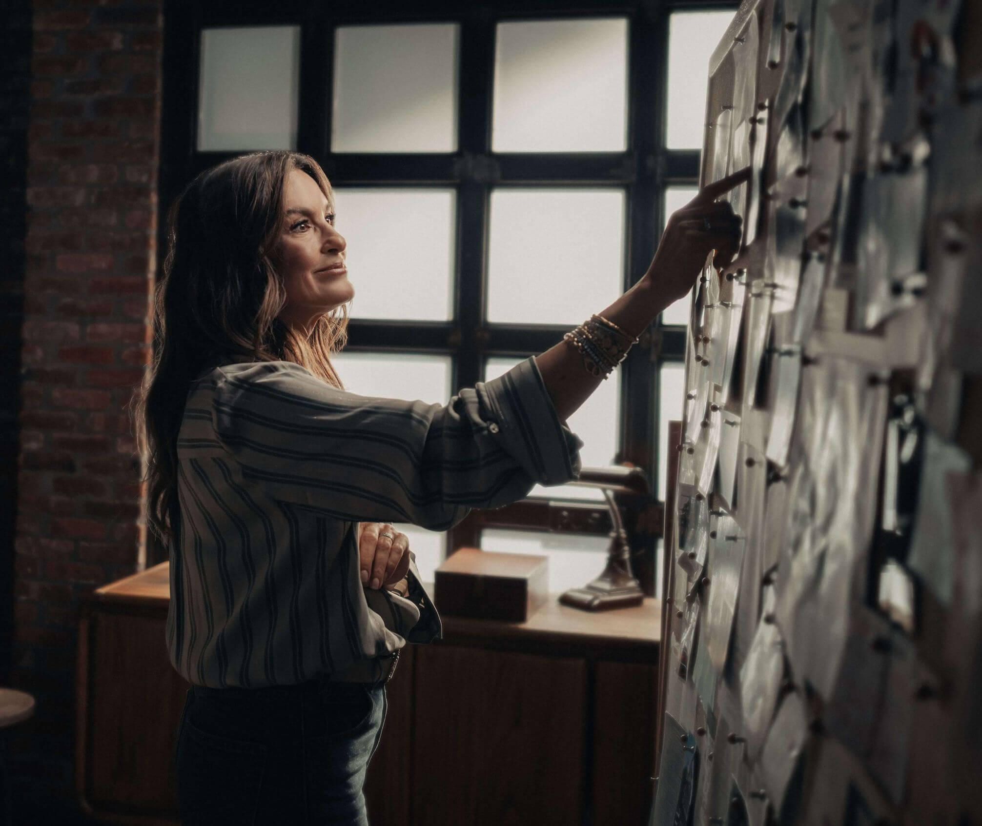 Mariska Hargitay standing in front of a pinboard of photos and reflecting on her father’s journey and recent research advances